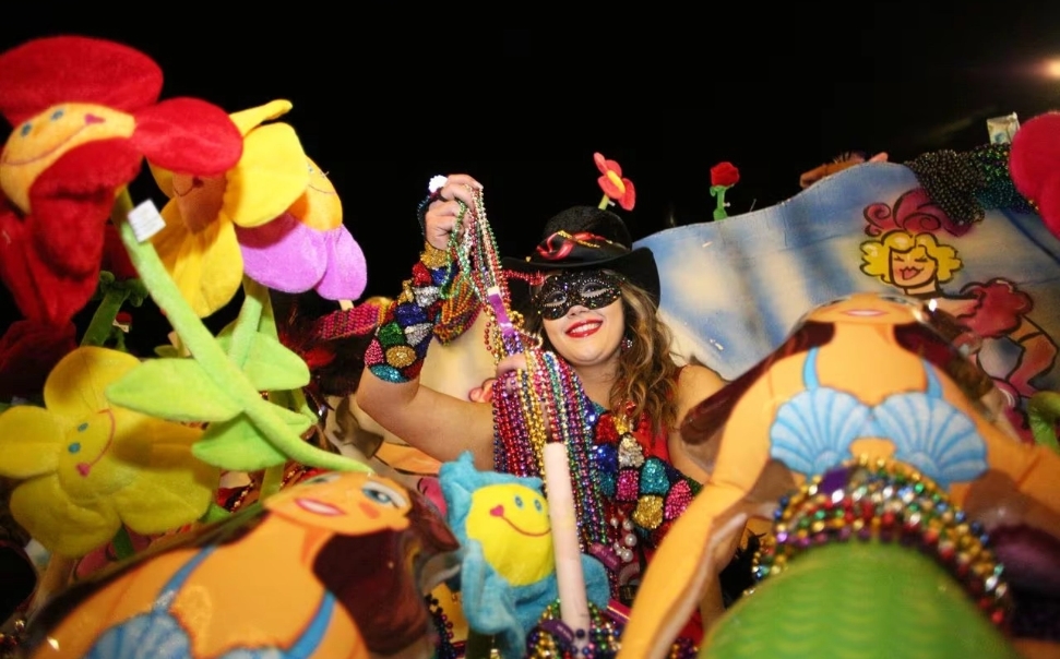woman tossing beads at mardi gras celebration in baldwin county